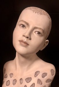 A sculpture of a female head and upper torso with a stylized, geometric cut-out pattern on the chest area, rendered in a monochrome palette.