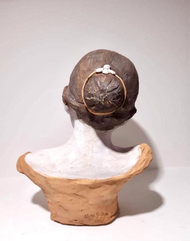 A terracotta bust of a ballerina with a neutral-colored dress and a contemplative expression. rear view